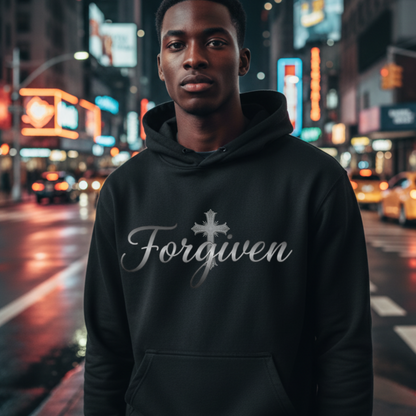 Person wearing a black hoodie with 'Forgiven' text on a city street at night.