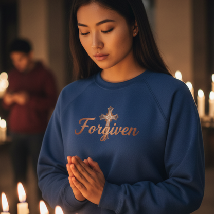 Woman wearing a blue sweatshirt with 'Forgiven' text in a candlelit setting